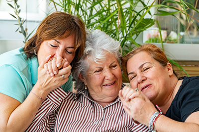 Happy elderly woman enjoying the affectionate bond of her daughter on Mother's Day. 